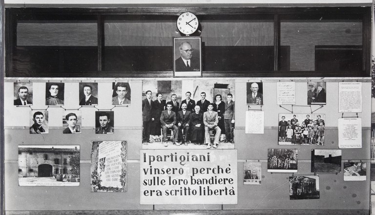 Pannello in legno posto nell'atrio della scuola con fotografie della famiglia Cervi e dediche